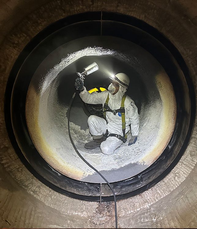 Technician applying high-emissivity coating inside industrial process equipment to improve thermal performance, protect substrates, and enhance operational efficiency.