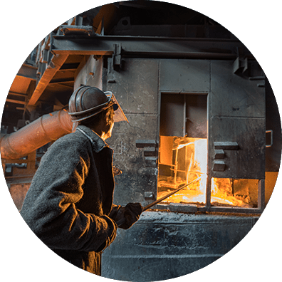 Refractory construction specialist working near furnace during high-heat installation in industrial plant.